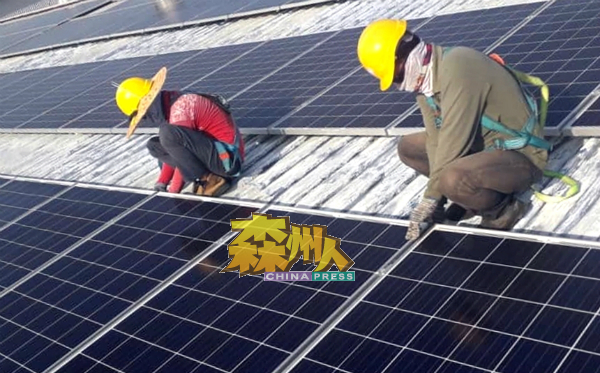 工作人员施工安装太阳能电池板，以便在预定的期限内完工。