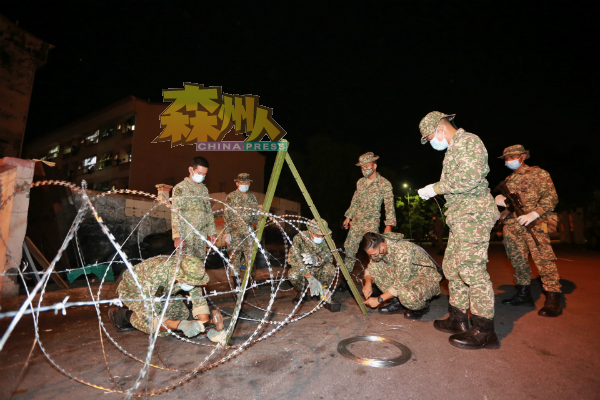 军人在为封锁卡亚感染群的外劳村准备铁蒺藜。