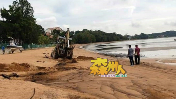 被污染的海滩动用挖土机来清理。