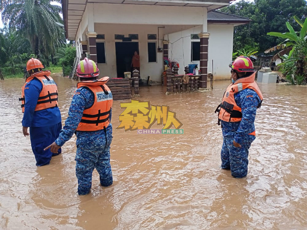 民防部队抵达现场，协助村民逃离水灾现场。