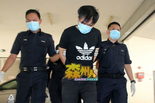 “儿子弑父案”的被告邓志明（中）被警员带上芙蓉推事庭面控。