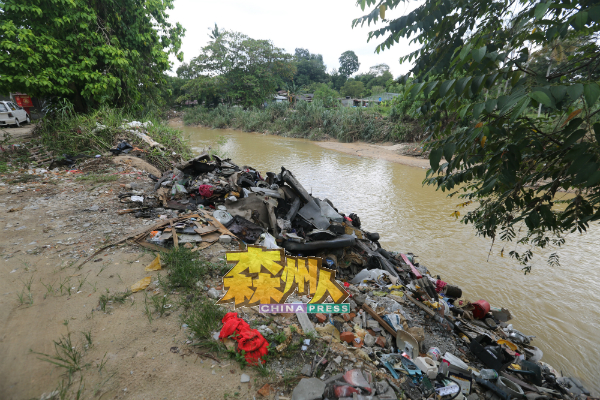 亚沙宁宜河边水灾后，河岸旁留着一堆被河水冲上岸的垃圾。