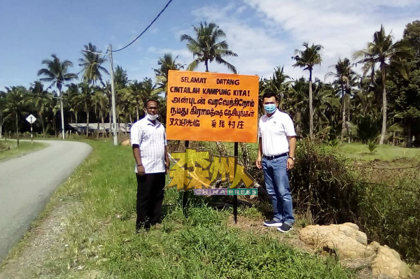 姆鲁根（左）为榕吉村民打造三语路牌，在新村各地安置。