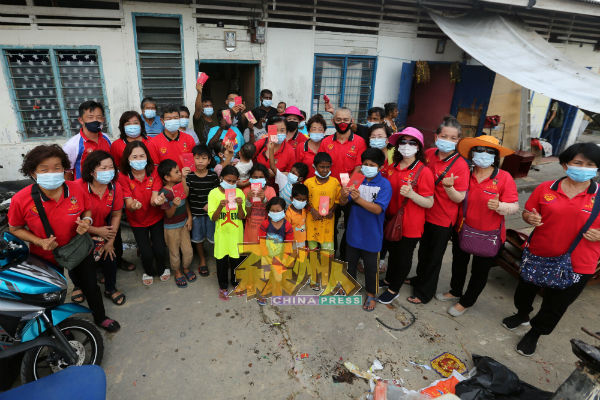 谢琪清（第二排左起）、陈云栏及森美兰同善福利协会的会员，为莫琛花园6户受灾家庭的26名男女老幼送暖。