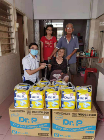 马来西亚善心组织芙蓉代表曾炜键（左）移交善款及成人尿片予许安妮以及父母。