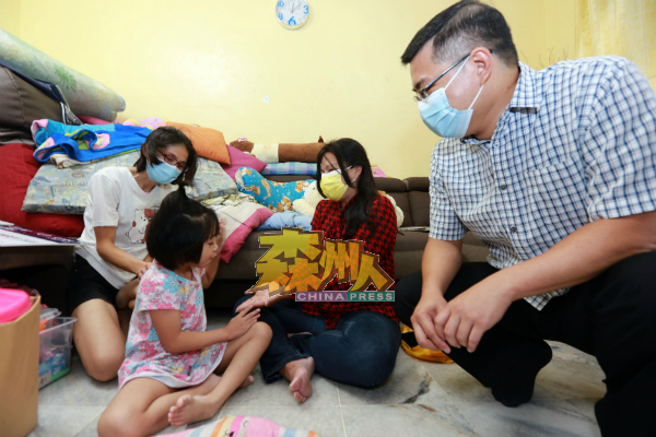 叶小瑂（右2）与患脑膜炎的6岁女童黄紫霖玩游戏，右为郑正成，左为黄紫霖的母亲冯翠芬。