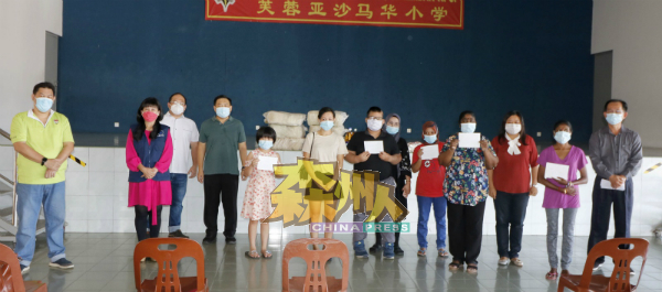 6名水灾家庭的孩子获得马华颁发100令吉购物券；左2起是刘雪燕、杨千篁和吴健南，右是吴文栋和右3何彩思。