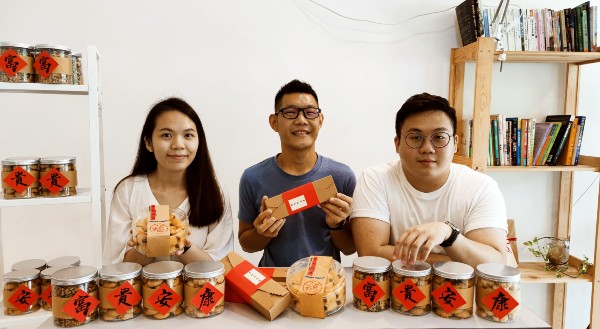罗秉耀（中）与友人梁佩玲（左）及陈佳豪一起制作年饼售卖。