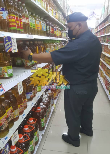执法官员在超市检查食油供应情况。