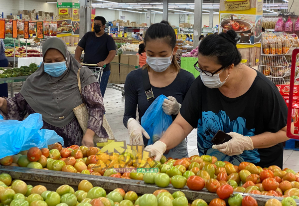 民众在选购食材时谨慎戴上手套，做好十足的防疫工作。
