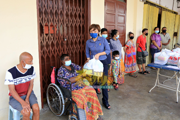 陈丽群（左3）派发援助品予爪哇岭的低收入群体。