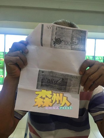 戚先生手持银行交给他存底的复印版假钞，提醒民众提高警惕。