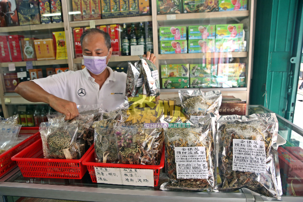 蔡智兴将各种凉茶材料，排放在篮子，方便消费者选购。