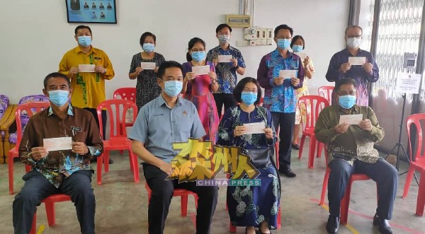 张聒翔（前排左2）颁发拨款支票给仁保区17所学校，作为开学增添防疫物品资金。