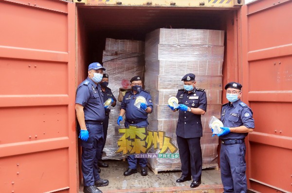 阿都拉夫（中）与官员展示起获的货柜箱中，发现藏有毒品的滑轮。