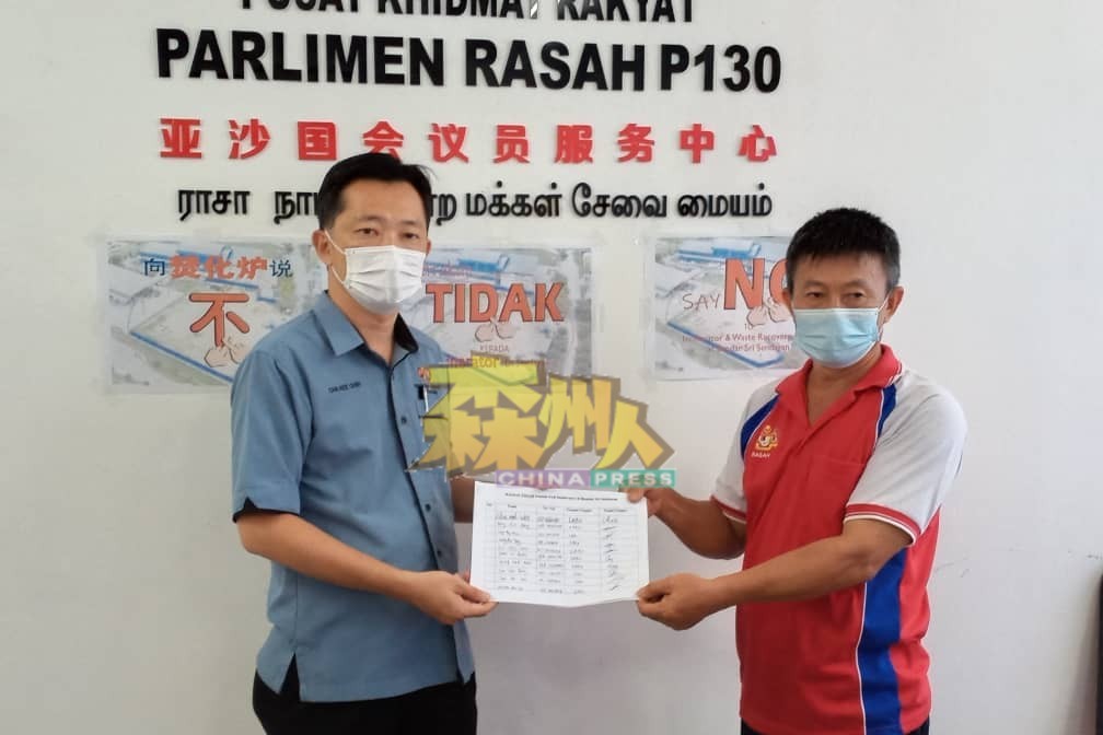 李恒华（右）移交来自拉务八哩新村，120个反对焚化炉的签名予谢琪清。