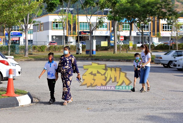 芙蓉新城高苑东华小学家长配合校方送孩子到学校接受新冠肺炎检测。