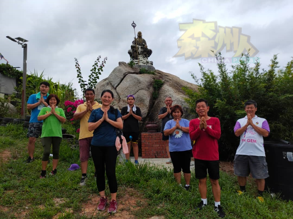 彭惠珠（前左）率领一行人在观音山岩石上的地藏王菩萨金身前，双手合十祈求国泰民安及风调雨顺。