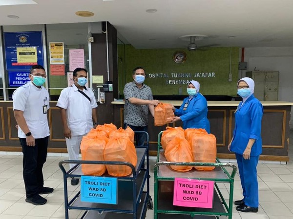 陆兆福（左3）把100盒封斋餐点移交予端姑惹化医院予前线医护人员。