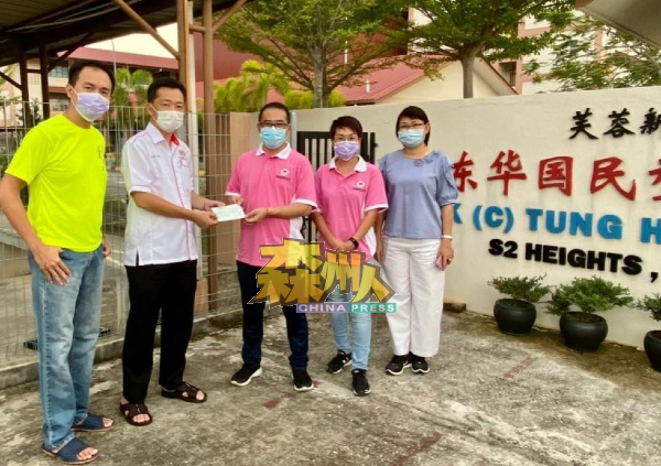 谢琪清（左2）移交捐款支票予东华小学家协主席陈杰义（右3），供学校进行消毒工作。