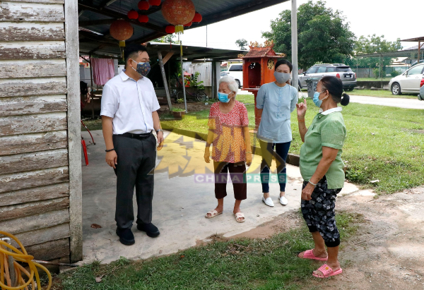 吴健南（左）向灾民了解洪水淹入屋内的情况。