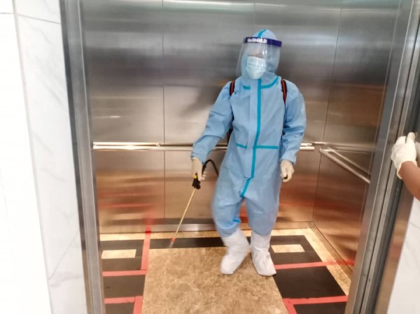 消毒队走进市政局电梯进行消毒工作。