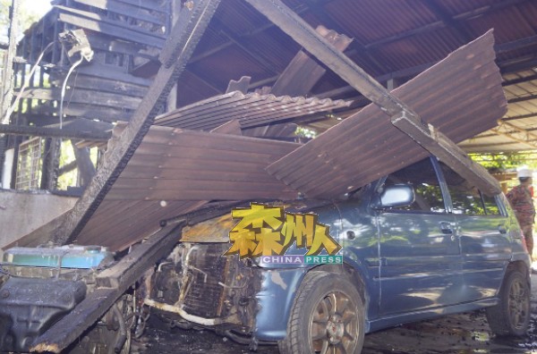 坍塌的木枋屋瓦把待修车辆的车顶压毁。