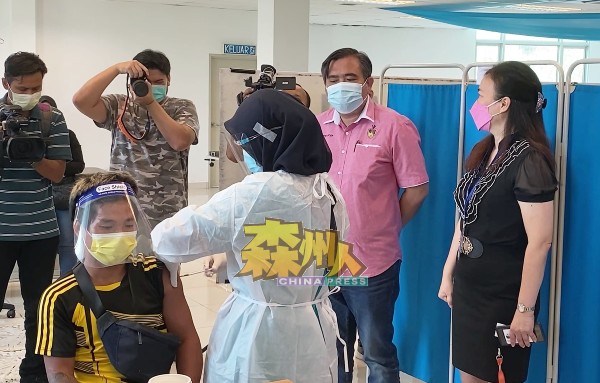 陆兆福（左2）巡视于芙蓉新城慈阁诊疗所施打疫苗的过程，右为卢琼莹。
