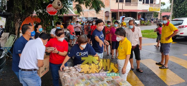 宋秝蓁（前右起）、叶理国、罗秀英及杨孔耀（左）向丹A新村村民派发200份饭盒。