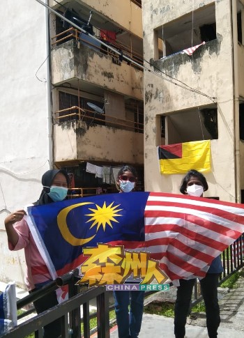 罗白区组屋的民众们响应国庆日的到来，在组屋范围挂起国旗。