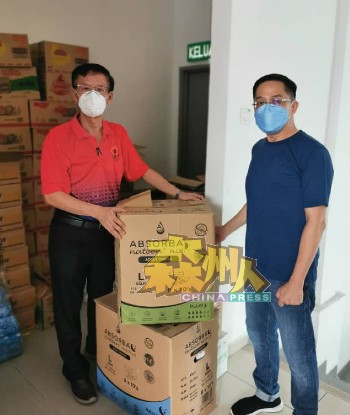 柯苠川（右）捐赠2箱成人尿片，由黄俊棠接领。