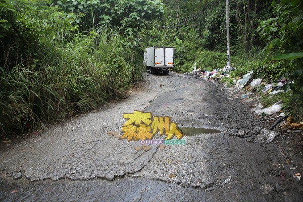 捷径的道路破烂不堪，路旁还布满各种垃圾。