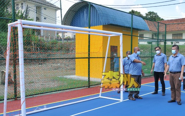 吴金财及欧开忠（右及右2）巡视完成提升工程甘榜武吉沉香足球场，村长罗斯兰（右3）汇报球场获提升的各个设施。