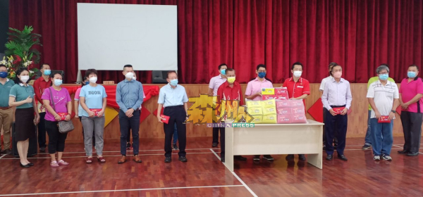 谢琪清（右4）移交口罩收纳袋予选区内的华小董家教代表。