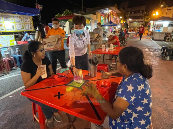 在芙蓉文化街用餐的民众，同样获得陈丽群（中）分派口罩和饼干。