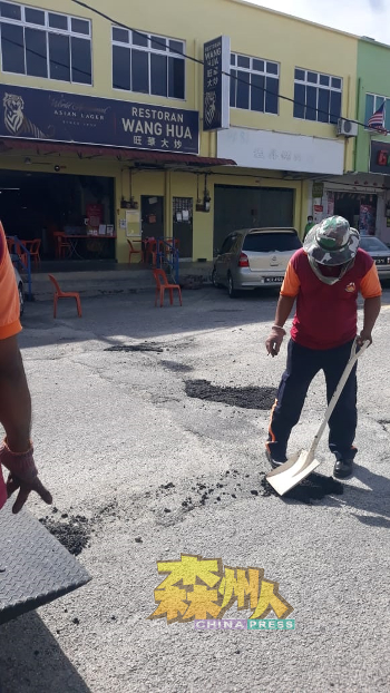 淡边县议会工作人员拿起铁铲把沥青，倒入路面的窟窿内再敲平便了事。