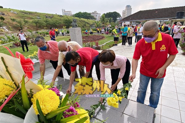 吕海庭（右起）、陈丽群、黄俊棠、李剑鸿及周世扬于义山总坟前，为先贤献上菊花。
