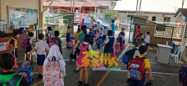 学生家长只获准在淡边新村华小校门外接送孩子，而且全程都严守标准作业程序。