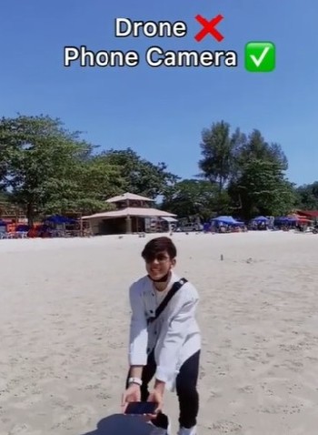 莫哈末查希鲁丁在波德申直落甘望海滨往上空抛手机，不必动用“无人机”就拍出令人惊艳的视频，并在社交媒体窜红。