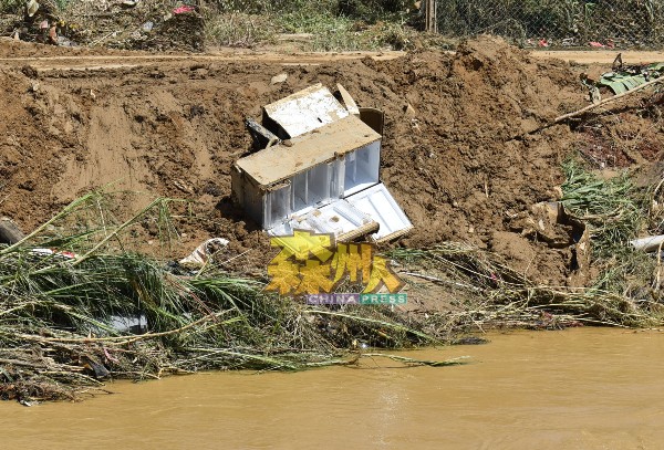灾黎的冰厨与洗衣机，被洪水冲至河岸边。
