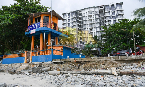 位于民防部队救生塔前方的海堤遭巨浪冲蚀，石块四散在海滩。