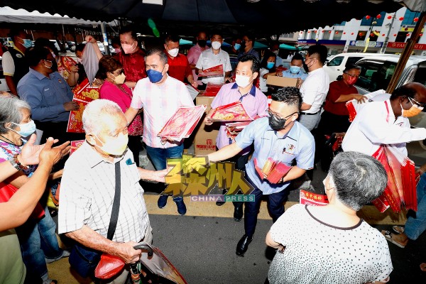森行动党州委会在准备进入芙蓉大巴刹前，许多市民已踊跃索取年画及红包封。