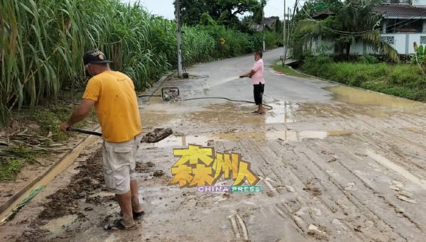 亚逸昆宁新村管委会携同村民，一齐清洗布满泥泞的通道。
