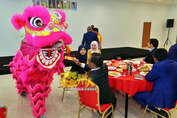 友族市议员从华人市议员口中学会华人习俗，马上封红包给舞狮。