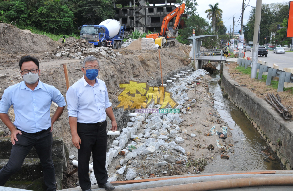 周世扬（右）及吴勇汉巡视敦依斯迈医生路旁正修建的防洪沟。