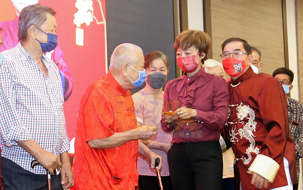 陈丽群（右2）颁赠红包予70岁以上的长者，右为龙国强。