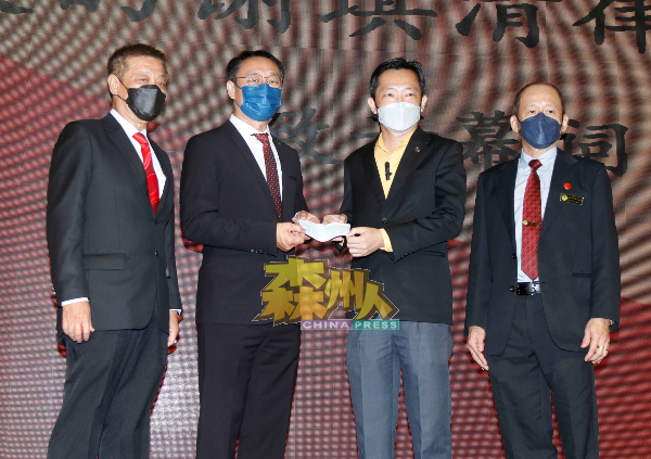 谢琪清（右2起）移交2万令吉支票拨款予谢崇岳，作为总会新设立的会员福利基金用途；左为谢华隆及谢耕伟（右）。