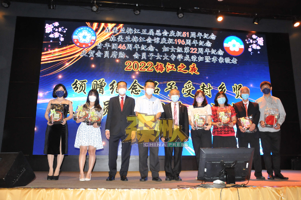 嘉宾与学成荣归的会员子女及荣膺勋衔的会员一起合照，左3起黄国强、谢琪清及陈怀国。