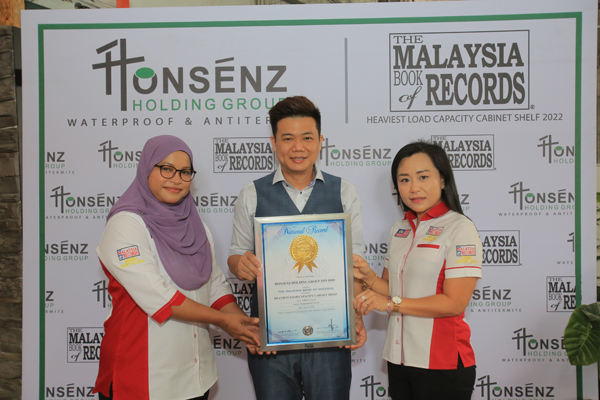《马来西亚纪录大全》经理李佩玲（右）及高级纪录顾问西蒂哈嘉尔（左）联合颁发奖状予萧榕宏。