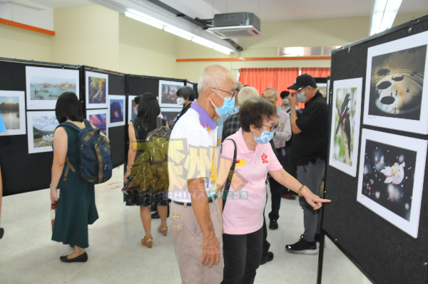 出席摄影展摄影人及民众参观摄影展。